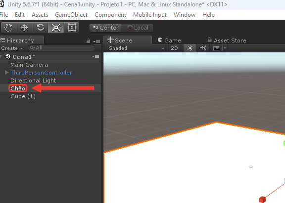 Painel Hierarchy do Unity com o objeto renomeado para Chão, selecionado com fundo cinza, entre a Directional Light e o Cube (1). Na Scene, o chão aparece com borda laranja. Uma moldura e uma seta vermelhas destacam o nome Chão